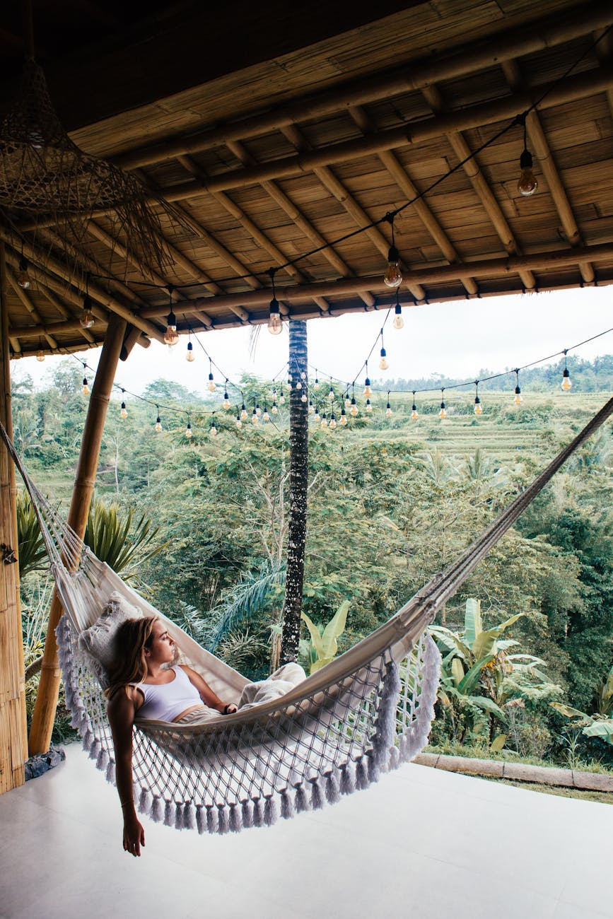 relaxed female tourist contemplating nature from hammock on terrace